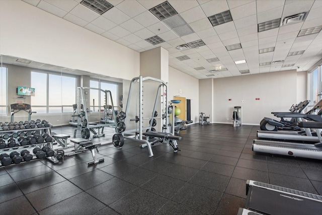 gym featuring baseboards, visible vents, and a paneled ceiling