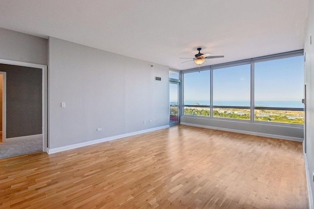 unfurnished room featuring baseboards, visible vents, light wood-style flooring, and a ceiling fan