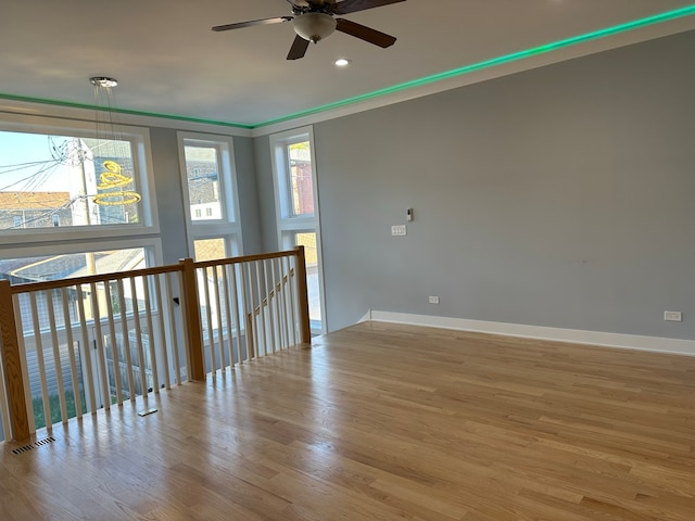 spare room with ceiling fan, ornamental molding, and light hardwood / wood-style floors