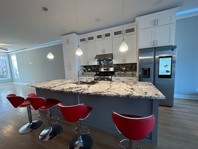 kitchen featuring a center island with sink, stainless steel appliances, crown molding, and sink