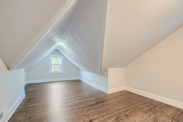 bonus room with lofted ceiling and dark hardwood / wood-style flooring