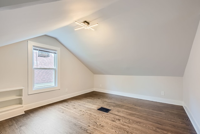 bonus room featuring vaulted ceiling and dark hardwood / wood-style flooring