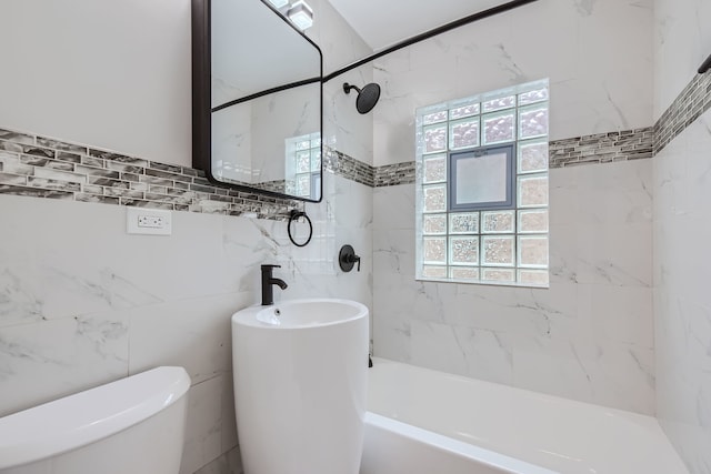 bathroom with tile walls, tiled shower / bath combo, and toilet