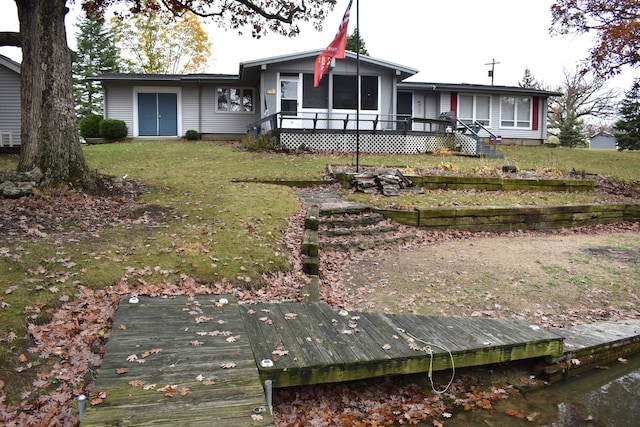 back of property featuring a wooden deck and a yard