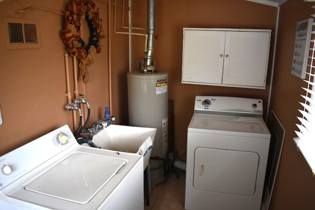 washroom with washer and clothes dryer, light tile patterned floors, and water heater