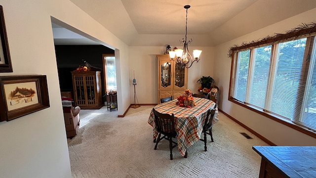 carpeted dining room with a chandelier