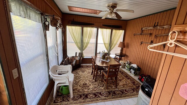 sunroom / solarium featuring ceiling fan, a skylight, and wood ceiling