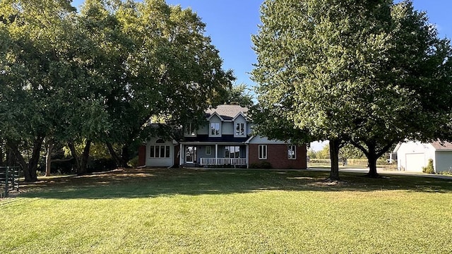 back of house with a lawn and covered porch