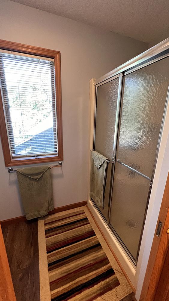 full bathroom with baseboards and a stall shower