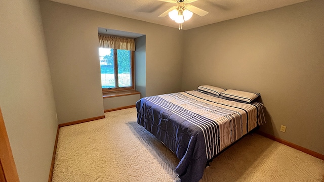 bedroom with ceiling fan and light colored carpet