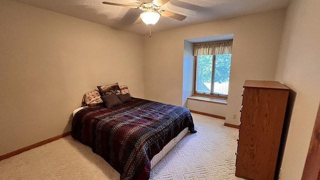 bedroom featuring a ceiling fan, baseboards, and light carpet