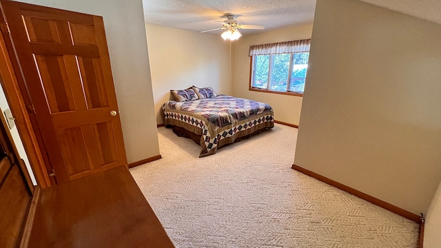 carpeted bedroom featuring a textured ceiling and ceiling fan