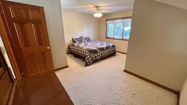 bedroom featuring baseboards, ceiling fan, light carpet, and a textured ceiling