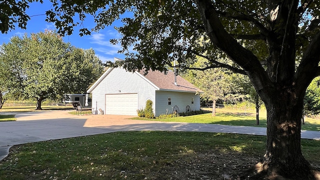 view of side of home with a garage and a lawn