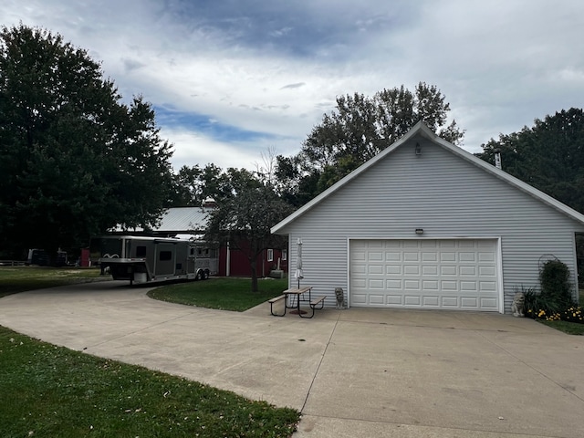 view of side of home featuring a garage and a lawn