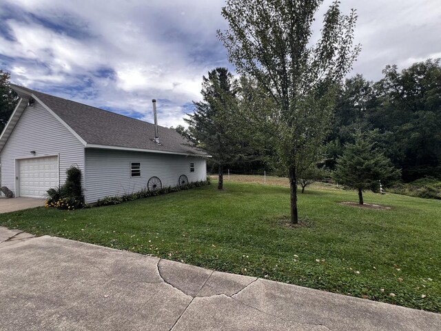 view of yard with an attached garage and driveway