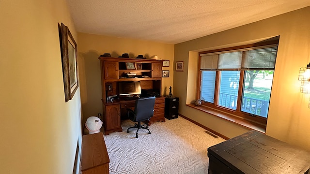 home office with a textured ceiling and light colored carpet