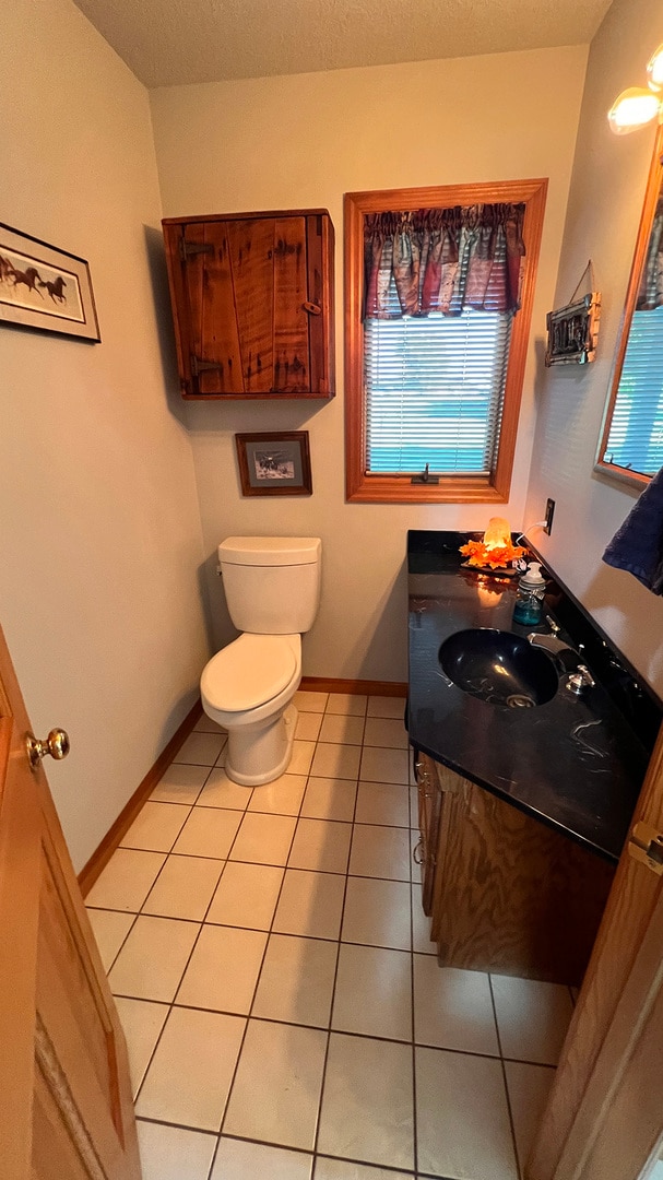 bathroom featuring vanity, toilet, and tile patterned floors