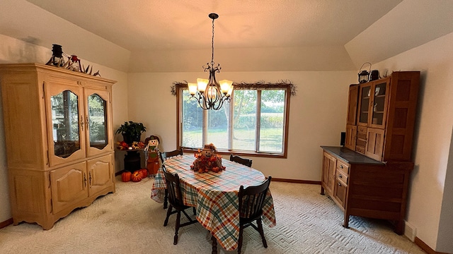 carpeted dining area featuring lofted ceiling and a chandelier