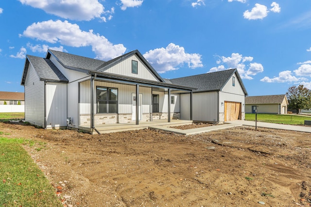 modern inspired farmhouse with a garage and covered porch