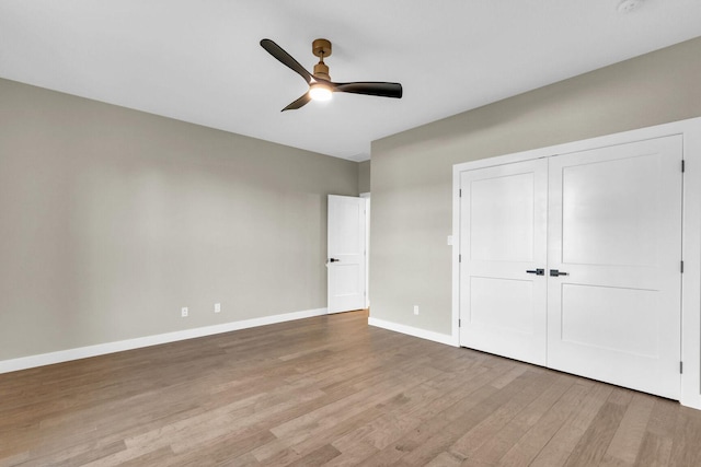 unfurnished bedroom featuring ceiling fan, a closet, and light wood-type flooring