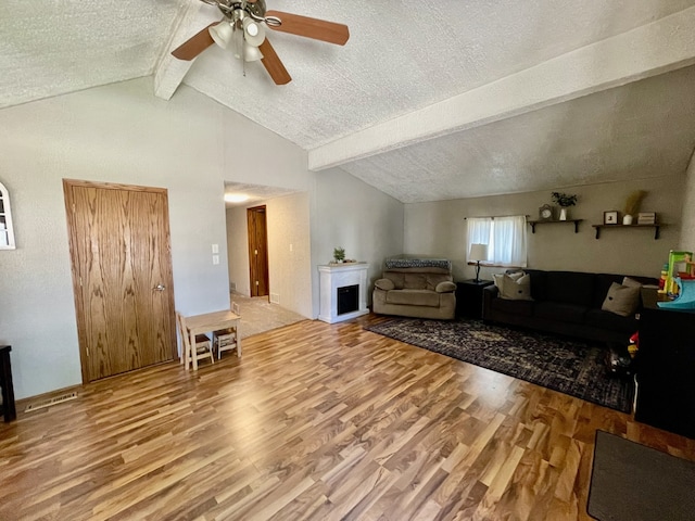 living room featuring wood-type flooring, a textured ceiling, lofted ceiling with beams, and ceiling fan