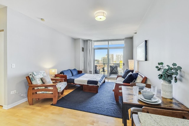 living room featuring light wood-type flooring and floor to ceiling windows