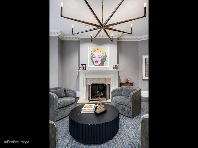 living room with baseboards, a tile fireplace, and a chandelier