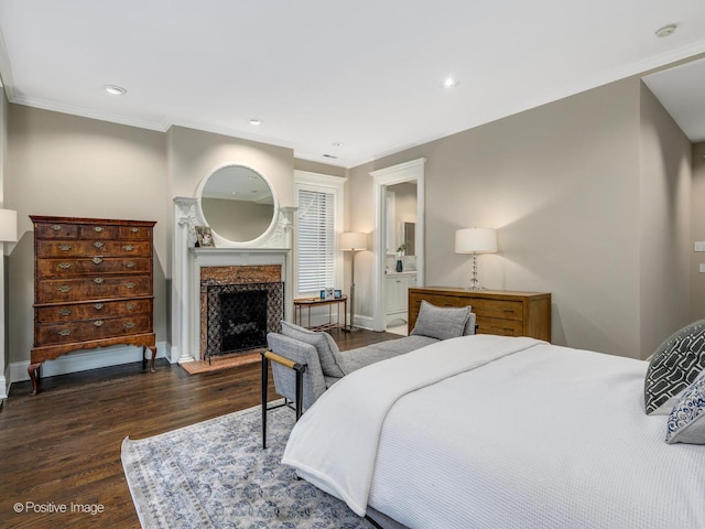 bedroom with a high end fireplace, crown molding, and dark wood finished floors