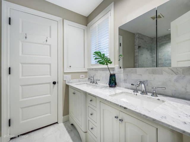 bathroom featuring tasteful backsplash, vanity, and a shower with door