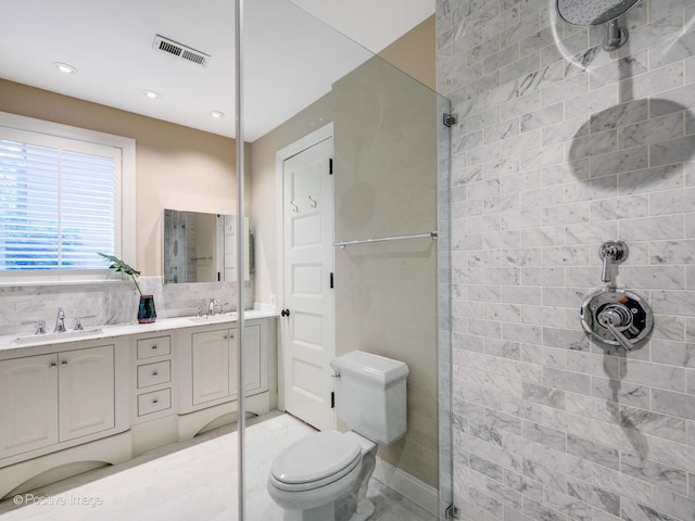 bathroom with backsplash, tiled shower, vanity, and toilet