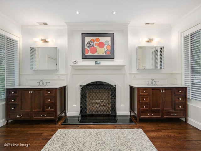 bathroom featuring crown molding, wood finished floors, and a sink