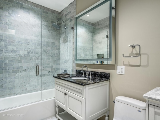 full bath featuring shower / bath combination with glass door, toilet, and vanity