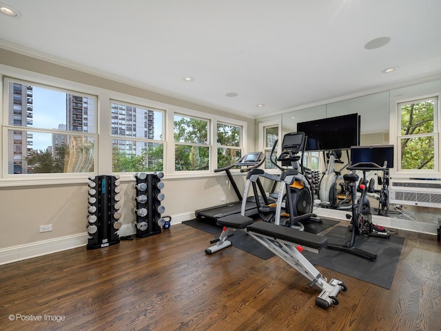 exercise area featuring recessed lighting, crown molding, baseboards, and wood finished floors