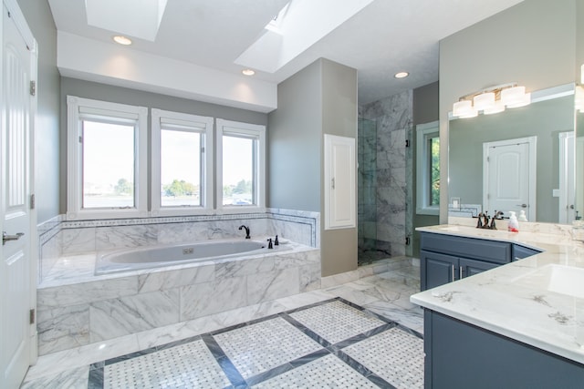 bathroom with independent shower and bath, vanity, and a skylight