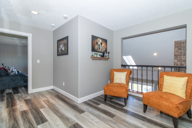 living area featuring wood-type flooring and a textured ceiling