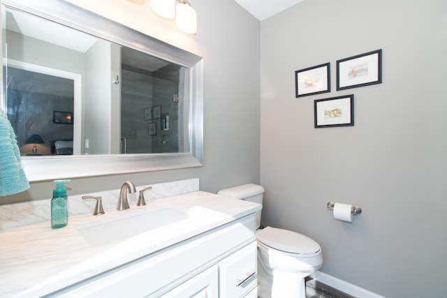 bathroom with vanity, toilet, and a shower with door