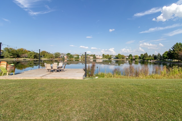 view of dock with a lawn and a water view