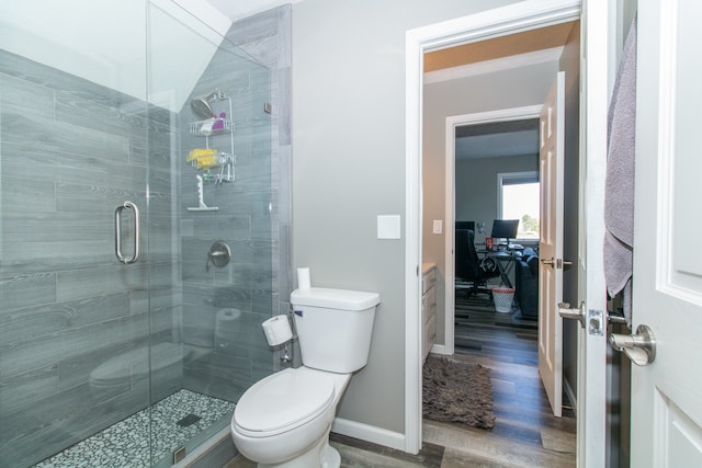 bathroom with walk in shower, toilet, and hardwood / wood-style floors