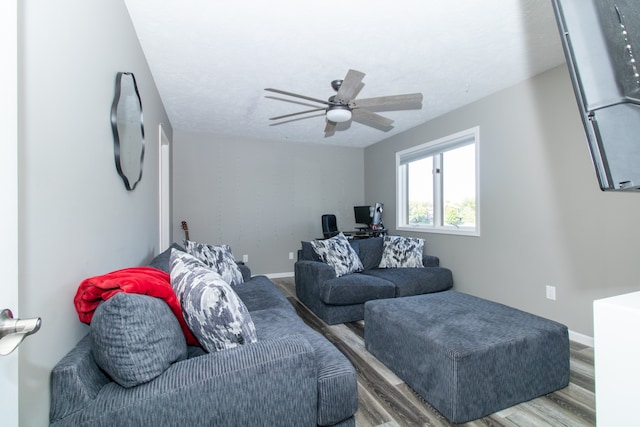 living room with ceiling fan, a textured ceiling, and wood-type flooring