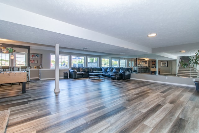 unfurnished living room featuring wood-type flooring, a textured ceiling, and a wealth of natural light