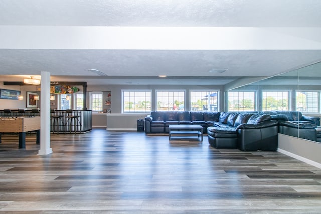 living room with a textured ceiling and dark hardwood / wood-style floors