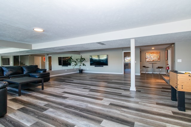 living room featuring a textured ceiling and dark hardwood / wood-style floors