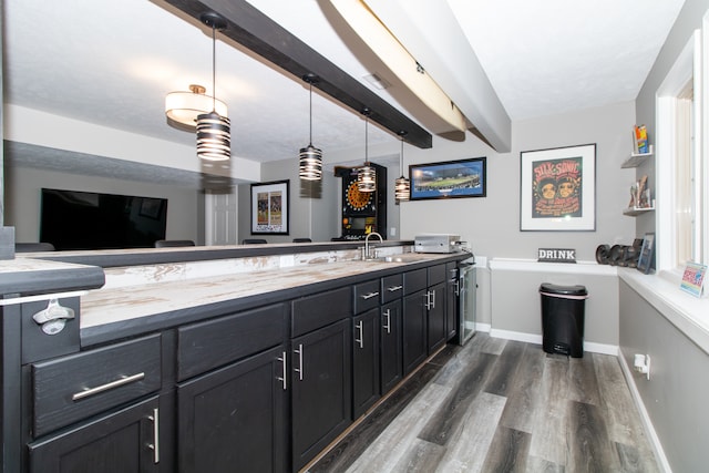 kitchen featuring beamed ceiling, sink, dark wood-type flooring, and decorative light fixtures