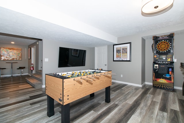 game room with a textured ceiling and dark hardwood / wood-style floors