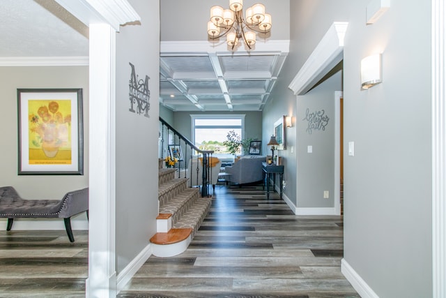 hall with beamed ceiling, ornamental molding, a chandelier, dark wood-type flooring, and coffered ceiling