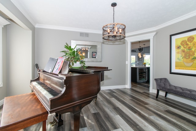 misc room featuring an inviting chandelier, crown molding, beverage cooler, and dark wood-type flooring