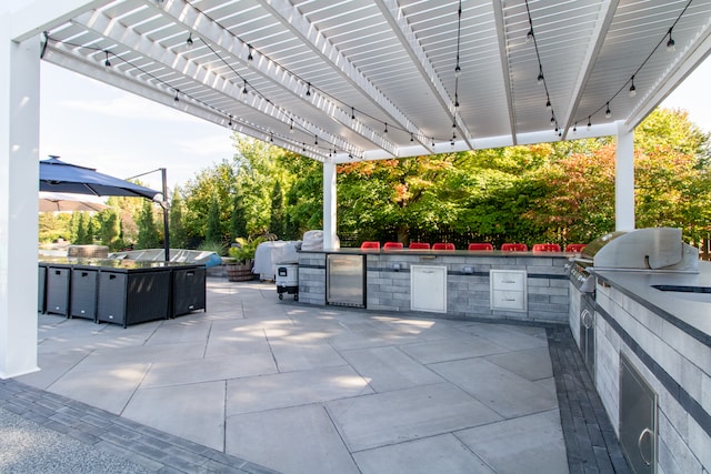 view of patio / terrace featuring a pergola and exterior kitchen