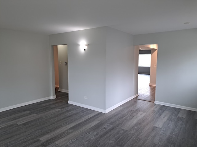 unfurnished room with dark hardwood / wood-style flooring