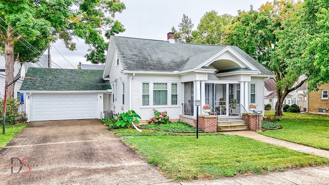 view of front facade featuring a garage, a front lawn, central AC, and covered porch